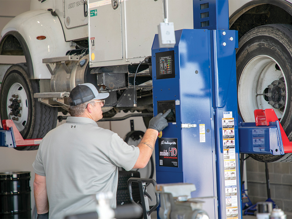 Tim Meyer uses the new mobile jacks to lift a bucket truck up for repairs.