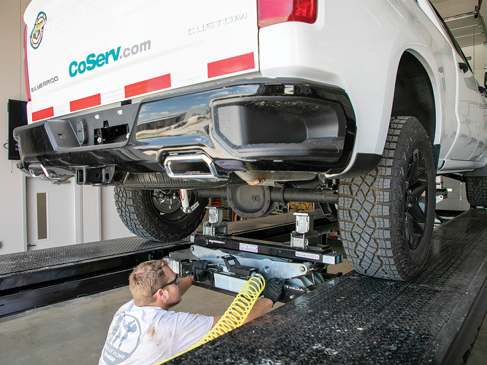 Tyler Garrett places jacks under the axle at the new Krum Fleet Service Center.