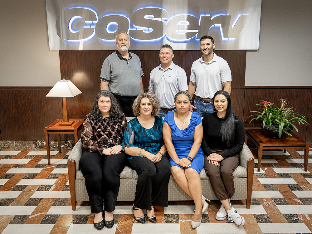 CoServ Finance Team. (Front Row L to R) Christine Scammel, Financial Accountant, Rebecca Fuller, Treasury Services Manager, Esther Lerma, Risk Management Clerk, Saphron Torres, Treasury Services Accountant. (Back row L to R) Ken Turner, Director of Finance, Glen Carpenter, Risk Management, Landon Jordan, Claims Management. Photo by KEN OLTMANN