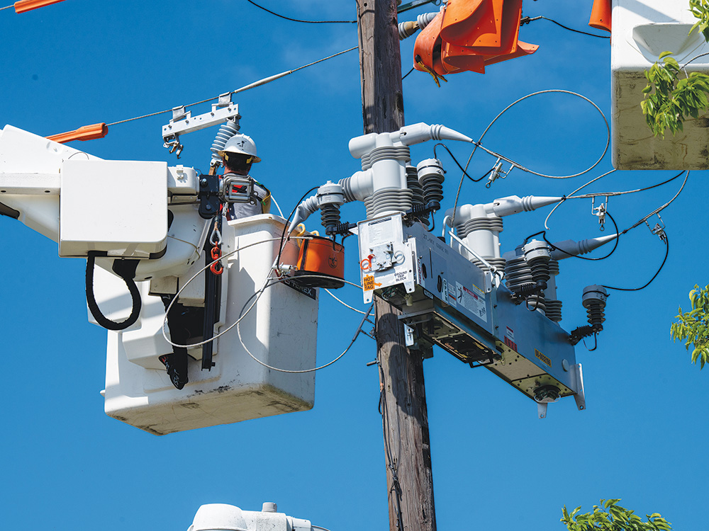 CoServ linemen install an Intelliruptor switch. Photo by BRIAN ELLEDGE