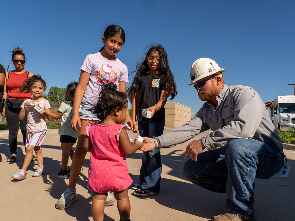 CoServ Lineman Austin Clayton passes out giveaways to kids during the Denton County Preparedness Fair at the Denton County Administrative Courthouse.